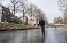 910714 Afbeelding van een schaatser op een bevroren Stadsbuitengracht ter hoogte van de Catharijnesingel te Utrecht, ...